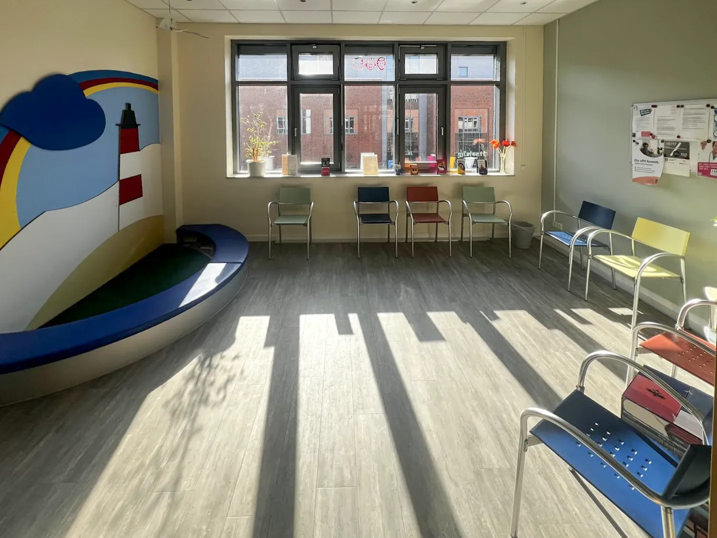 Wartezimmer der Hausarztpraxis Wentorf mit Sitzgelegenheiten und Leuchtturm-Motiv an der Wand